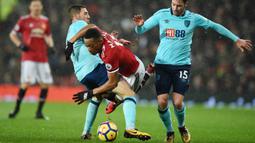 Striker Manchester United, Anthony Martial, terjatuh saat berebut bola dengan gelandang AFC Bournemouth, Brad Smith, pada laga Premier League di Stadion Old Trafford, Rabu(13/12/2017). Manchester United menang 1-0 atas AFC Bournemouth. (AP/Oli Scarff)