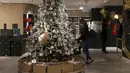 Seorang wanita yang mengenakan masker terlihat di samping pohon Natal di pusat perbelanjaan Harrods, London, Inggris, 2 Desember 2020. Sistem baru seiring berakhirnya karantina wilayah COVID-19 membagi Inggris ke dalam area-area dengan tingkat aturan pembatasan yang berbeda. (Xinhua/Han Yan)