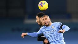 Bek Manchester City, Kyle Walker, duel udara dengan pemain Burnley, Dwight McNeil, pada laga Liga Inggris di Stadion Etihad, Sabtu (28/11/2020). City menang dengan skor 5-0. (Michael Regan/Pool via AP)