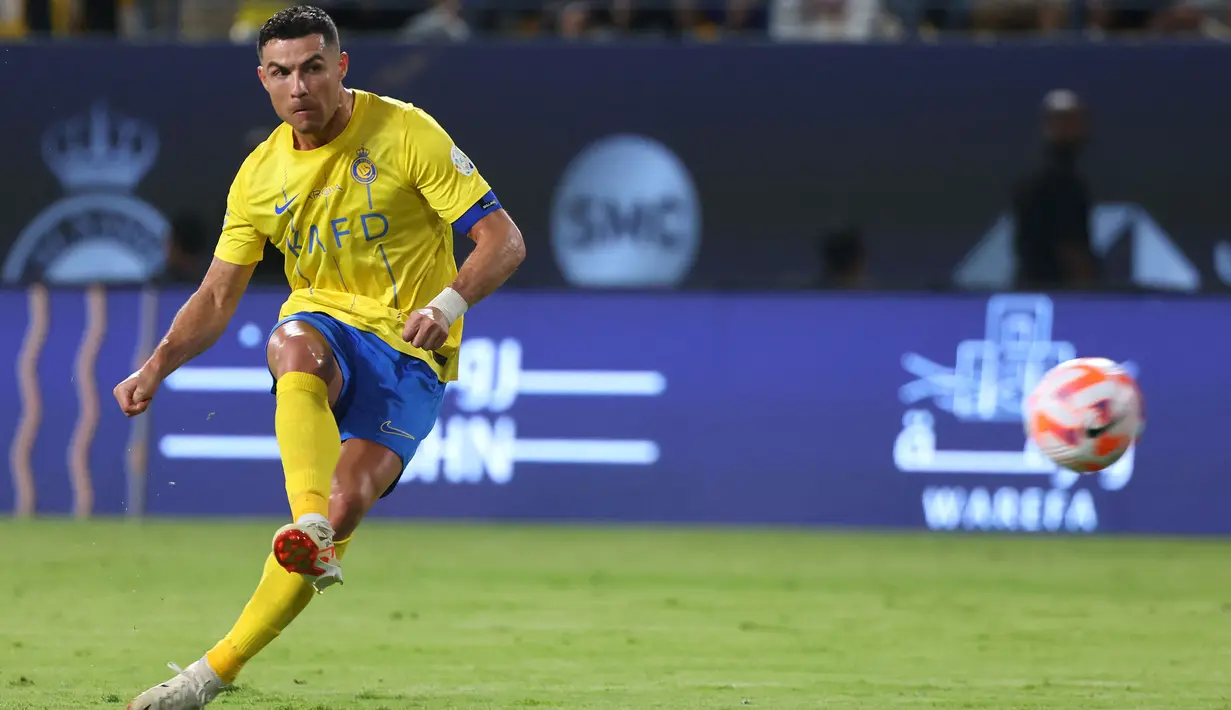 Striker Al Nassr, Cristiano Ronaldo melepaskan tendangan bebas ke gawang Damac pada laga pekan ke-10 Liga Arab Saudi 2023/2024 yang berlangsung di King Saud University Stadium, Riyadh, Sabtu (21/10/2023) malam WIB. (AFP/Fayez Nureldine)