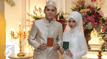 Pasangan Artis, Ben Kasyafani dan Nesyana Ayu Nabila berpose sambil memegang buku nikah usai ijab kabul di  kawasan Mega Kuningan, Jakarta, Sabtu (30/07). (Liputan6.com/Herman Zakharia)