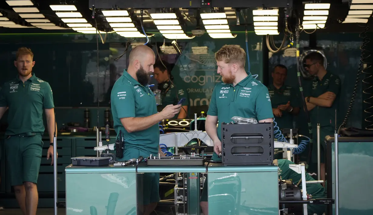 Teknisi mengerjakan mobil pembalap Aston Martin Sebastian Vettel dari Jerman di garasi tim di Sirkuit Baku, Baku, Azerbaijan, Kamis (9/6/2022). Persaingan di tiga besar klasemen Formula 1 2022 masih ketat. (AP Photo/Sergei Grits)