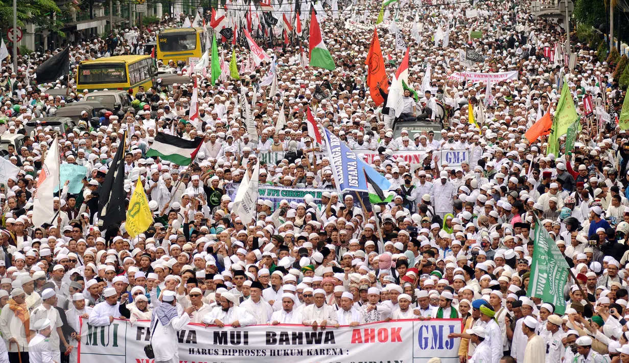 Ribuan Umat muslim  membentangkan spanduk dan mengibarkan bendera saat melakukan aksi menuju Balai Kota Jakarta, Jumat (14/10). Mereka mendesak Gubernur DKI Jakarta, Basuki Tjahaja Purnama mundur. (Liputan6.com/Hemi Fithriansyah)
