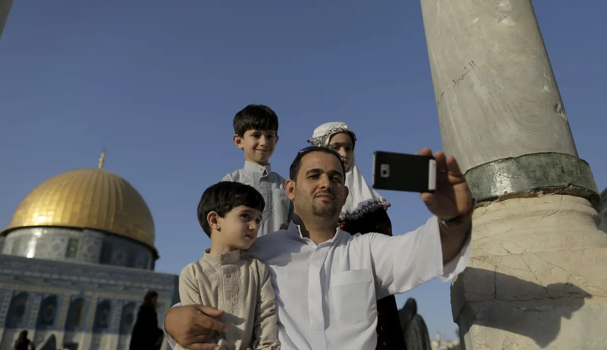 Muntasser Ne'erat (31) berfoto selfie dengan anak-anaknya di depan kubah Ash-Shakhrah di area Masjid , Yerusalem, 29 Juni 2015. (REUTERS/Ammar Awad) 