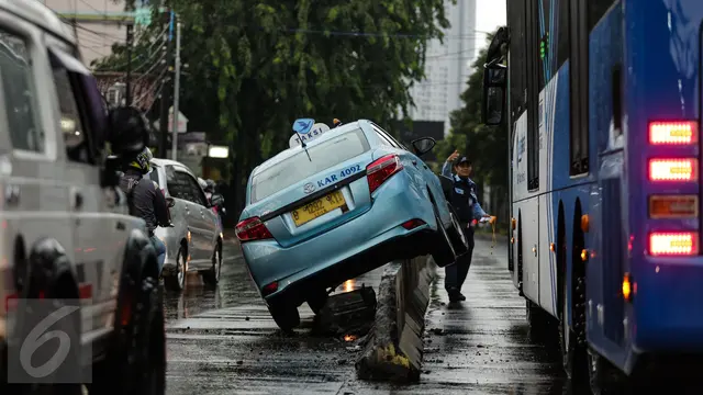 Sebuah Taksi Tabrak Pembatas Busway Halte Jati Padang