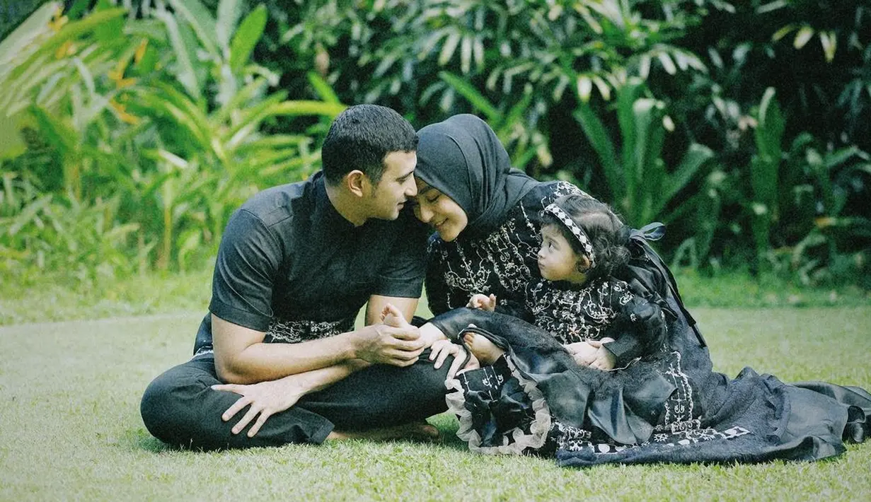 Dengan latar taman hijau, keluarga berjuluk good looking ini tampil kompak dengan busana lebaran serba hitam dari Ivory Studio.