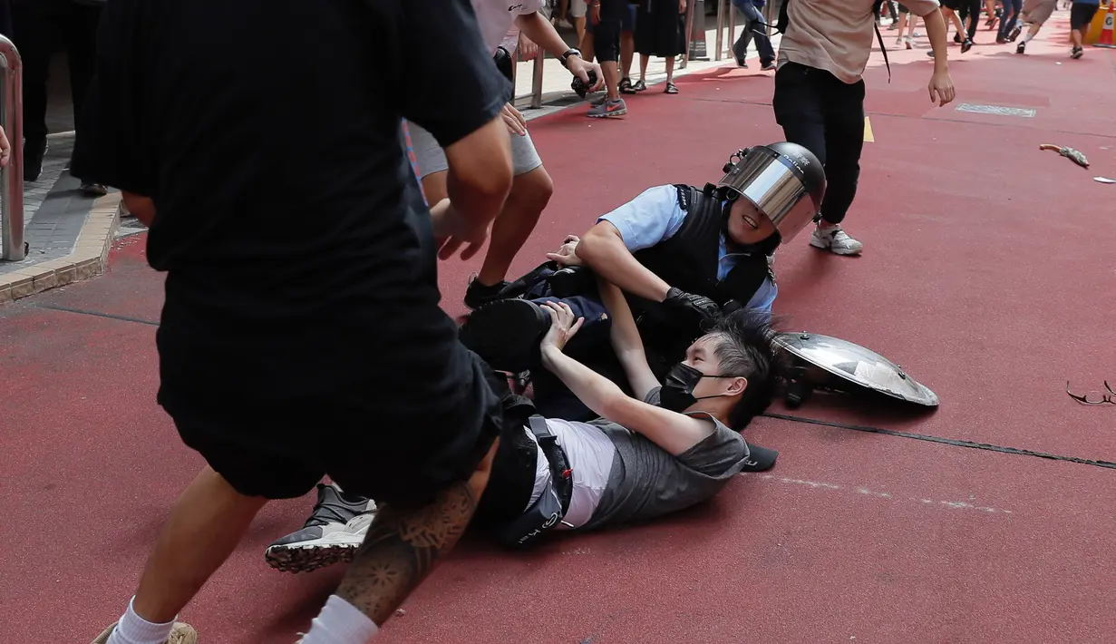Polisi menahan seorang pria muda setelah perkelahian antara pendukung pro-China dengan demonstran antipemerintah di Amoy Plaza, Distrik Kowloon Bay, Hong Kong, Sabtu (14/9/2019). Beberapa orang ditahan dalam bentrokan ini. (AP Photo/Kin Cheung)