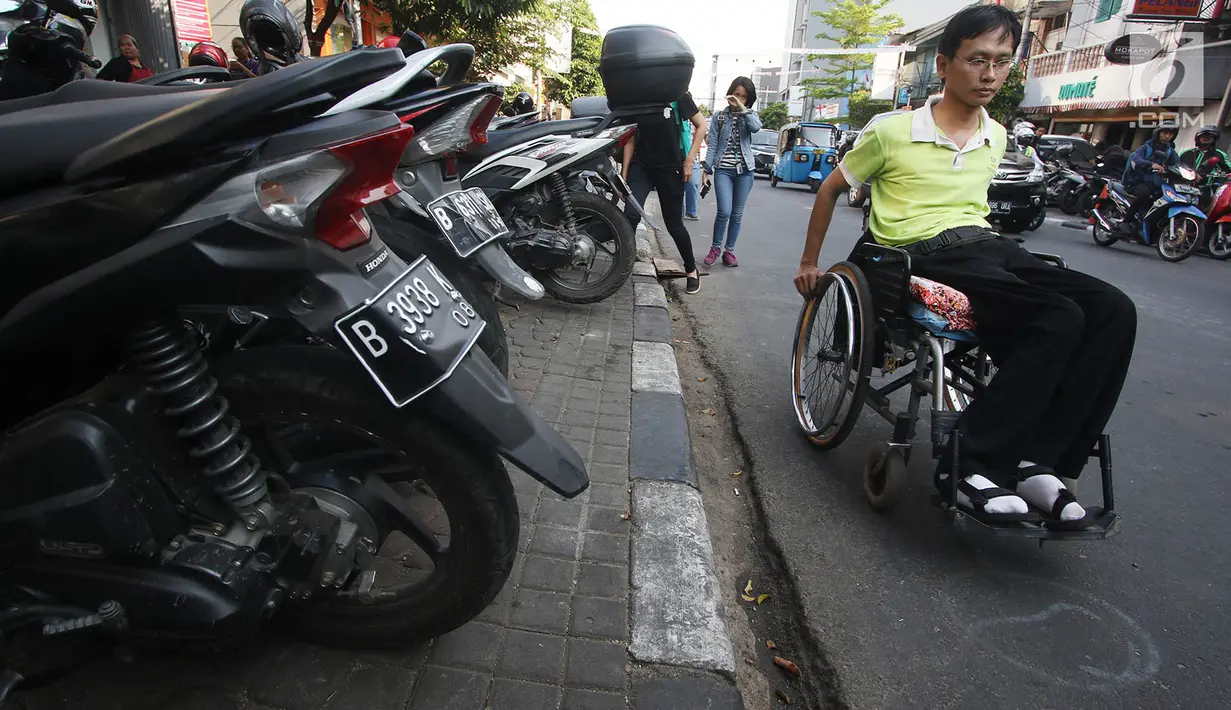 Penyandang disabilitas melintas di samping trotoar saat kampanye Bulan Patuh Pedestrian di Jalan Sabang, Jakarta, Rabu (30/8). Kampanye dilakukan untuk memantau fasilitas akses pejalan kaki untuk disabilitas. (Liputan6.com/Immanuel Antonius)