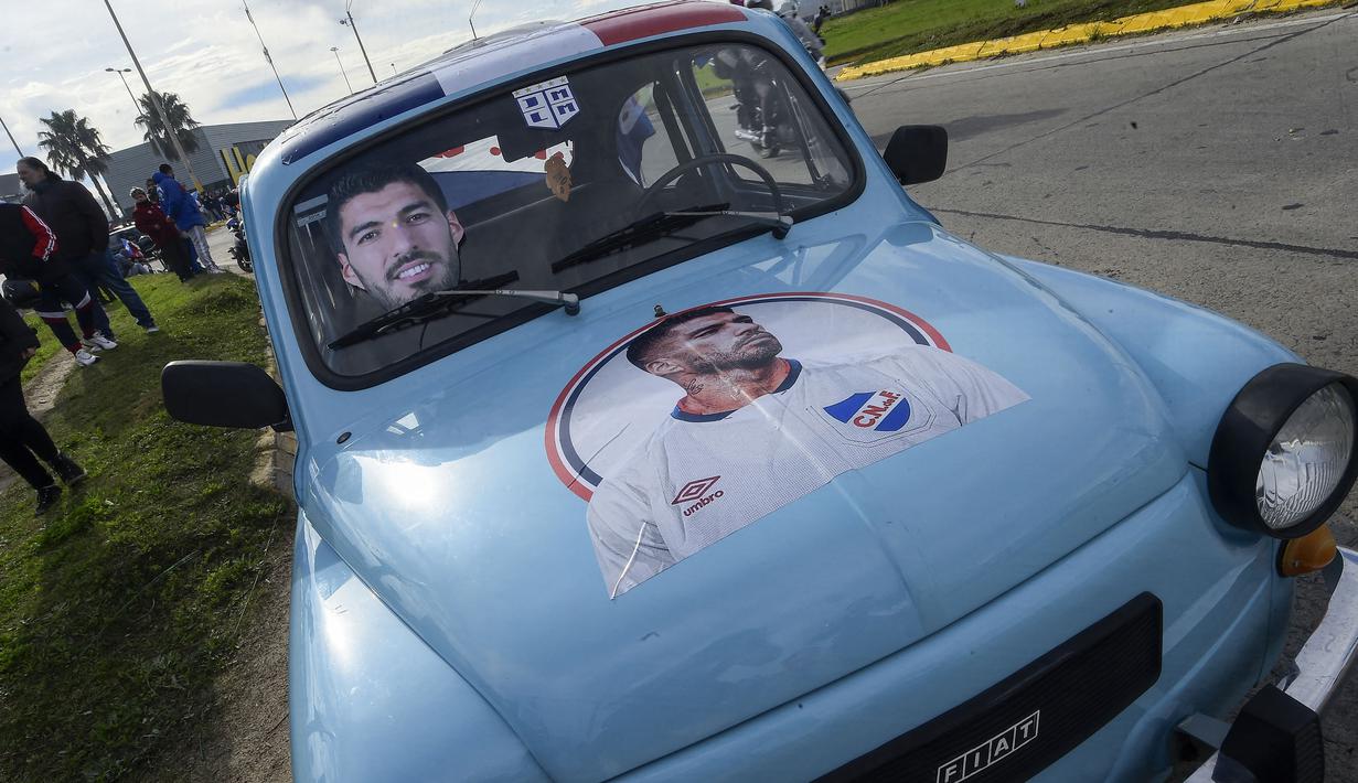 Sebuah mobil yang dihias gambar Luis Suarez terparkir saat sang pemain menghadiri upacara penyambutan sebagai pemain baru Nacional di Stadion Gran Parque Central, di Montevideo, pada 31 Juli, 2022. Luis Suarez kembali ke Uruguay untuk bergabung dengan Nacional, klub tempat ia memulai karirnya 17 tahun lalu sebagai salah satu striker terbaik di generasinya. (AFP/Pablo Porciuncula)