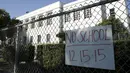Sebuah kertas berisi pemberitahuan libur terpasang di Florence Nightingale Middle School, Los Angeles, Selasa (15/12). Seluruh sekolah di Los Angeles, ditutup selama satu hari pada Selasa (15/12), karena adanya ancaman teror bom. (REUTERS/Jason Redmond)