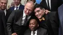 Presiden Rusia Vladimir Putin berfoto bersama legenda sepak bola Brasil, Pele (tengah) dan legenda Argentina, Diego Maradona (kanan) saat menghadiri undian Piala Dunia 2018 di Moskow, Rusia (1/12). (AFP Photo/Sputnik/Alexey Nikolsky)