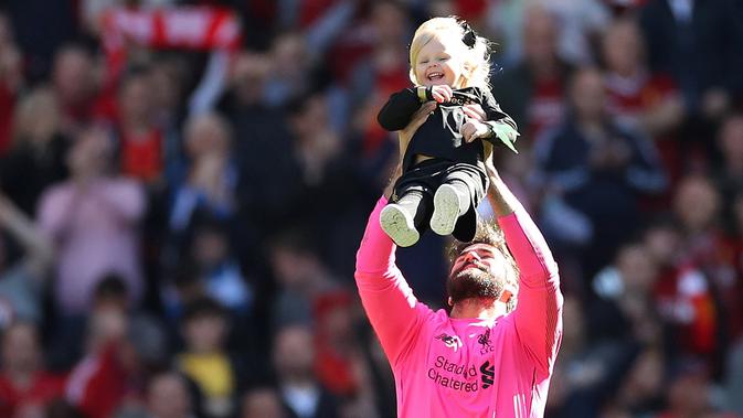 Kiper Liverpool, Alisson Becker, bermain dengan anaknya usai pertandingan melawan Wolverhampton Wanderers pada lanjutan Liga Inggris di Anfield, Inggris (12/5/2019). Liverpool gagal meraih gelar Liga Inggris walaupun berhasil mengalahkan Wolverhampton Wanderers 2-0. (AFP Photo/Carl Recine)