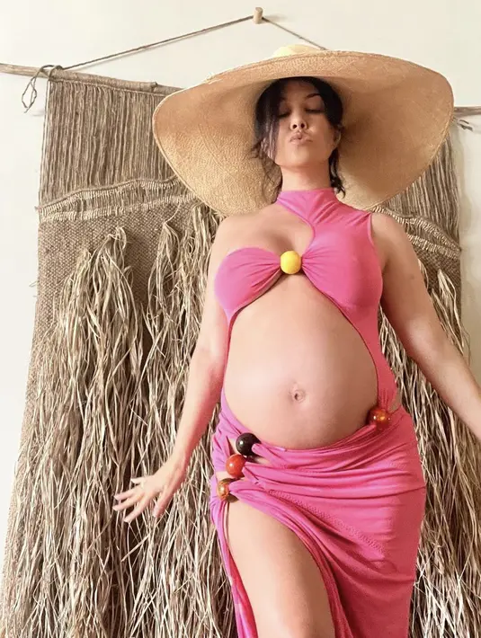 <p>Kourtney Kardashian yang sedang babymoon di Hawaii bersama suaminya Travis Barker, tampil bak Barbie mengenakan serba pink dengan dress potongan asimetris, turtleneck dan belahan kaki tinggi di satu sisi. Bola kayu warna-warni menjepit bra dan menghiasi roknya, yang memiliki potongan berlapis di satu sisi. @kourtneykardash</p>