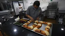 Chef Francisco Vasquez menghias kue tradisional Rosca de Reyes di toko rotinya sehari sebelum Epiphany atau Hari Tiga Raja, Mexico City, Meksiko, 5 Januari 2022. (AP Photo/Fernando Llano)