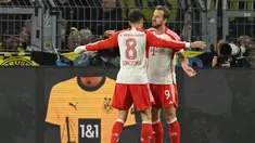 Penyerang Bayern Munchen #09 Harry Kane berselebrasi bersama Leon Goretzka setelah mencetak gol ke gawang Borussia Dortmund pada pekan kesepuluh Bundesliga di Stadion Signal Iduna Park, Minggu (5/11/2023) dinihari WIB. (INA FASSBENDER / AFP)