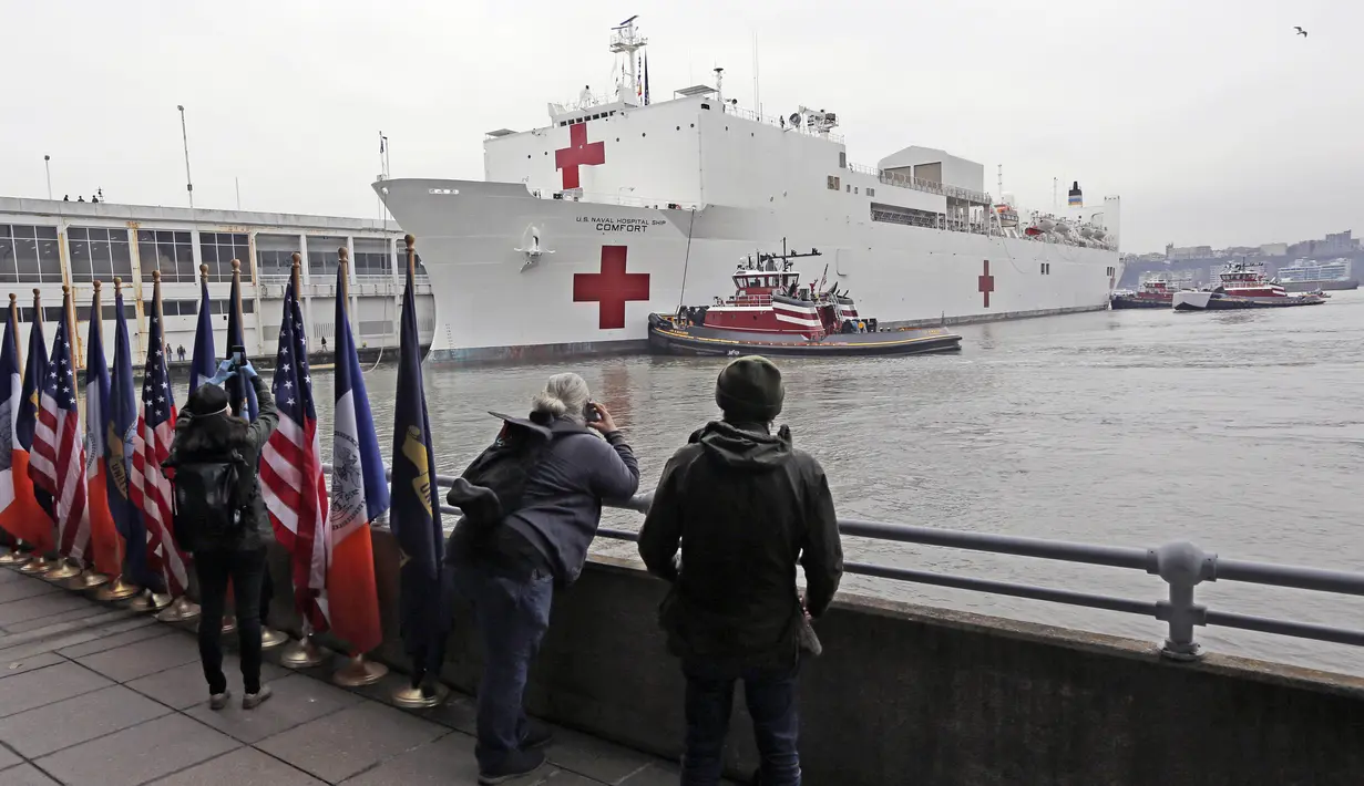 Awak media melihat kedatangan Kapal Rumah Sakit Angkatan Laut USNS Comfort di Dermaga 90, New York, Amerika Serikat, Senin (30/3/2020). Hingga Selasa (31/3/2020), jumlah kasus virus corona COVID-19 di Amerika Serikat sebanyak 163.429, sebanyak 3.008 di antaranya meninggal. (AP Photo/Kathy Willens)