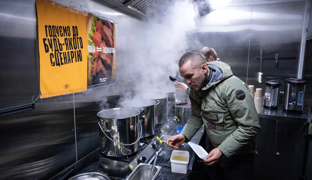 Hingga Minggu (25/1/2026), sekitar 1.700 gedung apartemen di Kyiv masih belum mendapatkan pasokan pemanas. Tampak dalam foto, para veteran the 3rd Separate Assault Brigade Angkatan Bersenjata Ukraina menyajikan makanan panas gratis bagi orang-orang di lingkungan perumahan yang rumahnya tanpa listrik setelah serangan udara Rusia berulang kali terhadap sektor energi negara itu di Kyiv, Selasa 27 Januari 2026. (AP Photo/Danylo Antoniuk)