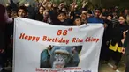 Anak-anak sekolah India membawa spanduk untuk merayakan ulang tahun simpanse bernama Rita yang berusia 58 tahun di sebuah kebun binatang di New Delhi (14/12). Rita merupakan simpanse tertua di India yang kini usianya 58 tahun. (AFP Photo/Money Sharma)