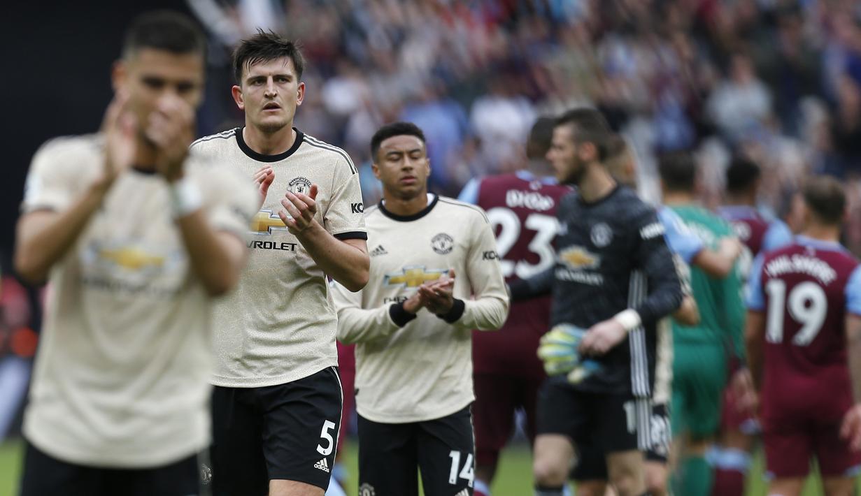 Bek Manchester United, Harry Maguire, menyapa suporter usai dikalahkan West Ham pada laga Premier League di Stadion London, London, Minggu (22/9). West Ham menang 2-0 atas MU. (AFP/Ian Kington)