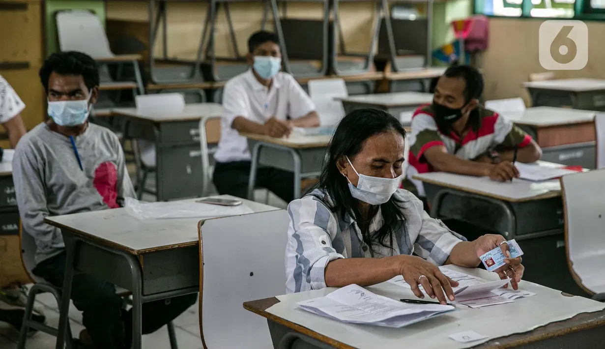 Warga menunggu untuk mengambil Bantuan Sosial Tunai (BST) di SMAN 111, Jakarta, Selasa (19/1/2021). Pemprov DKI Jakarta menyalurkan BST sebesar Rp 300 ribu kepada 1.055.216 KK mulai Januari hingga April 2021. (Liputan6.com/Faizal Fanani)