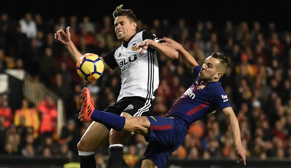 Bek Valencia, Gabriel, berebut bola dengan bek Barcelona, Jordi Alba, pada laga La Liga Spanyol di Stadion Mestalla, Valencia, Minggu (26/11/2017). Kedua klub bermain imbang 1-1. (AFP/Jose Jordan)