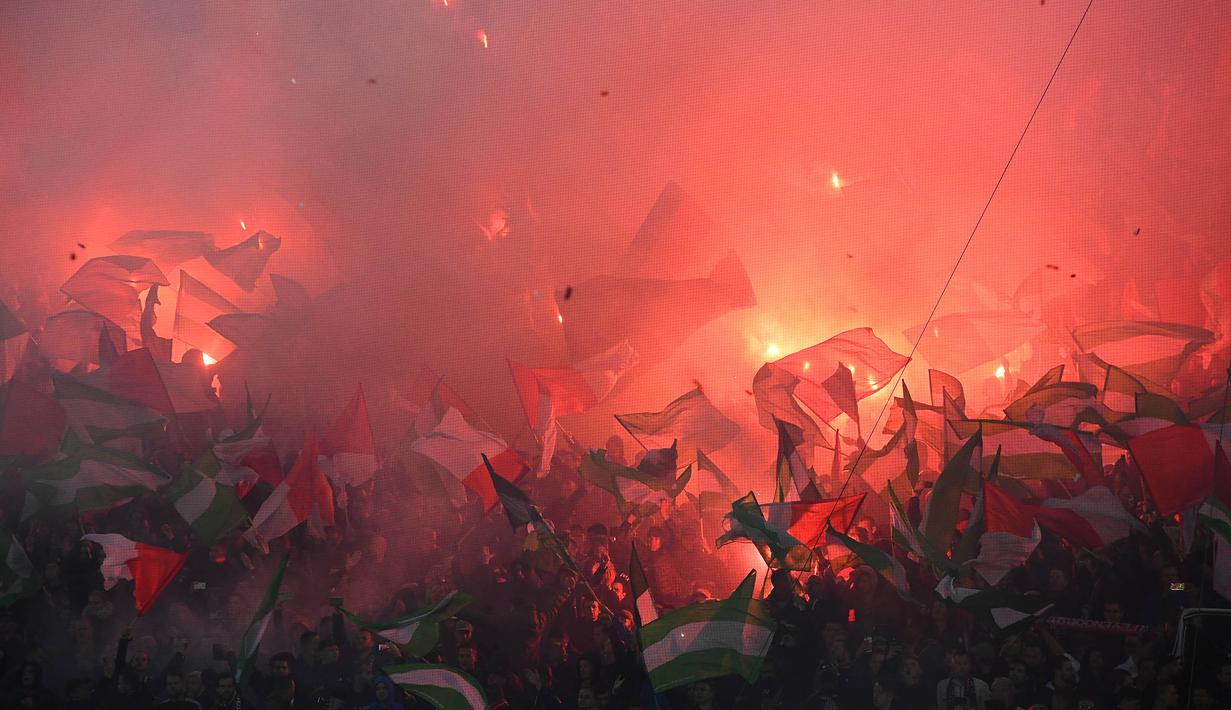 Suporter Feyenoord menyalakan flare saat melawan Manchester CIty pada laga Liga Champions di Stadion Feyenoord, Rotterdam, Rabu (13/9/2017). Feyenoord kalah 0-4 dari City. (AFP/Emmanuel Dunand)