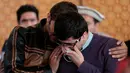 Kerabat dari korban kecelakaan pesawat Pakistan International Airlines (PIA) menangis saat menunggu tes DNA di rumah sakit PIMS di Islamabad, Pakistan, Kamis (8/12). (REUTERS / Caren Firouz)