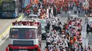 Bus tingkat dengan kap terbuka membawa pelari Torch Relay Asian Games 2018 di Jalan Jendral Sudirman, Jakarta, Sabtu (18/8). Hari terakhir kirab obor Asian Games ini api abadi dibawa dari Tugu Monas hingga Gelora Bung Karno. (Liputan6.com/ Fery Pradolo)