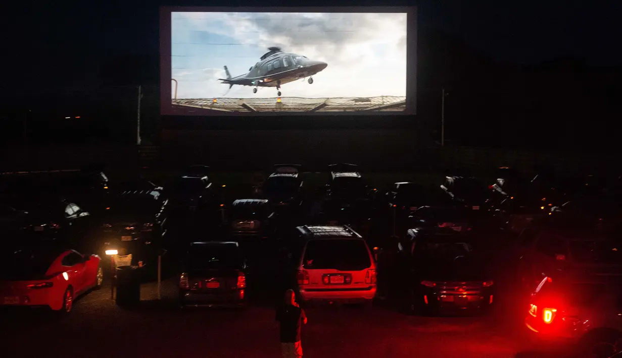 Puluhan mobil terparkir di depan layar bioskop saat pemutaran film drive-in di Family Drive-in di Virginia, 10 Agustus 2018. Menonton film di luar ruangan atau drive-in merupakan bagian penting dalam industri hiburan di Amerika. (AFP PHOTO/Nicholas Kamm)