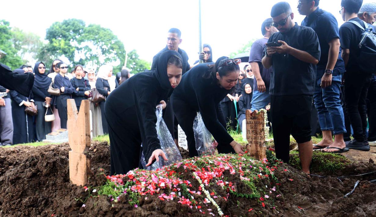 Selain Reza Arap, sejumlah kerabat dan sahabat Lula Lahfah juga tampak hadir mengiringi jenazah Lula Lahfah ke tempat peristirahatan terakhir. Tampak dalam foto, sejumlah kerabat dan sahabat menabur bunga di atas makam Lula Lahfah di Tempat Pemakaman Umum (TPU) Rawa Terate, Cakung, Jakarta Timur, pada Sabtu (24/1/2026). (Kapanlagi.com/Budy Santoso)