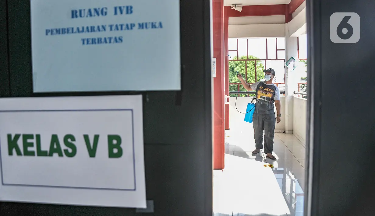 Petugas menyemprotkan disinfektan pada lorong kelas di SD Negeri Malaka Jaya 07 Pagi, Jakarta, Kamis (26/8/2021). Pemprov DKI berencana membuka kembali sekolah untuk pembelajaran tatap muka terbatas pada Senin (30/8) setelah status PPKM turun ke level 3. (merdeka.com/Iqbal S Nugroho)