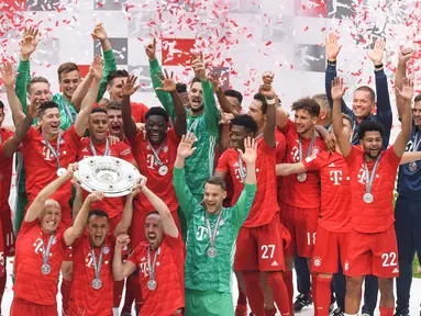 Pemain Bayern Munchen mengangkat trofi Bundesliga usai mengalahkan Frankfurt di Allianz Arena, Jerman, Sabtu (18/5). Munchen menang 5-1 atas Frankfurt. (Christof Stache/AFP).