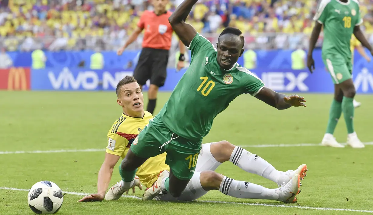 Pemain Senegal, Sadio Mane (depan) jatuh saat berebut bola dengan pemain Kolombia, Mateus Uribe pada laga terakhir grup H di Samara Arena, Samara, Rusia, (28/6/2018). Kolombia menang 1-0. (AP/Martin Meissner)