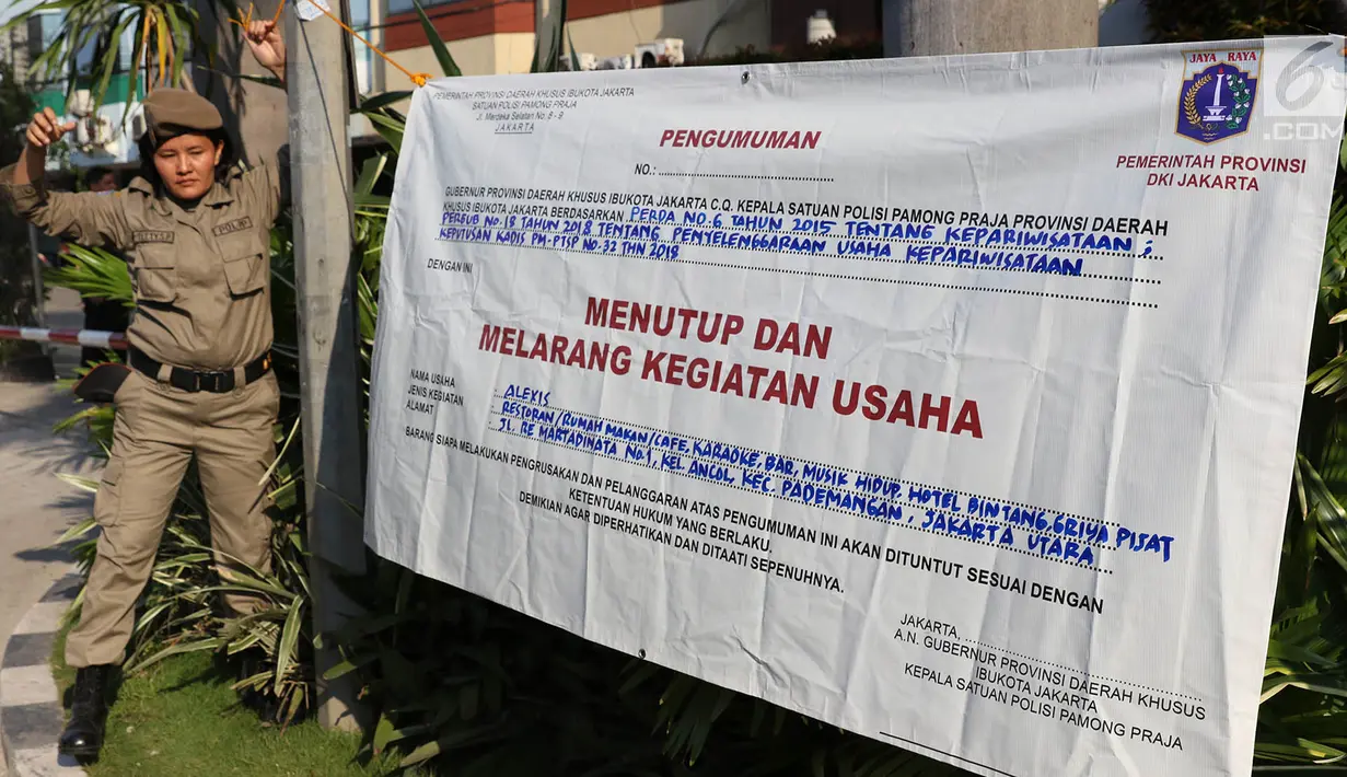 Personel Satpol PP wanita memasang spanduk penyegelan untuk menutup Hotel Alexis, Jakarta, Kamis (29/3). Ibu-ibu personel Satpol PP ini bertugas untuk memastikan tidak ada kegiatan usaha apapun di Hotel Alexis. (Liputan6.com/Immanuel Antonius)