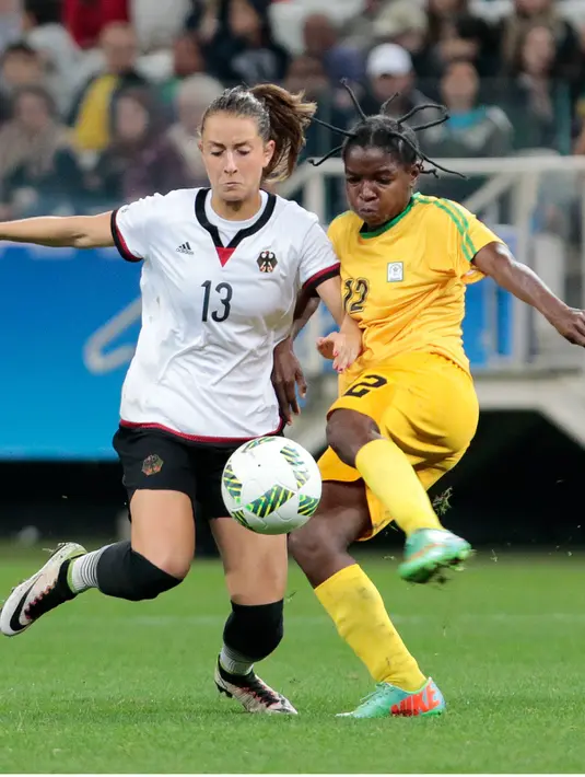 Marjory Nyaumwe berusaha menghalau bola yang dibawa pemain Jerman, Sara Daebritz i Grup F Olimpiade Rio 2016 di Korintus Arena, Brasil, (3/8). Dengan gaya rambut nyentriknya Marjory Nyaumw jadi perhatian ribuan nitizen. (AFP PHOTO/Miguel SCHINCARIOL)