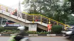 Pekerja mengecat jembatan penyeberangan orang (JPO) di kawasan Cipayung, Jakarta Timur, Rabu (30/5). Pengecatan dilakukan untuk merawat JPO agar tidak kusam dan lebih nyaman digunakan oleh pejalan kaki. (Liputan6.com/Immanuel Antonius)