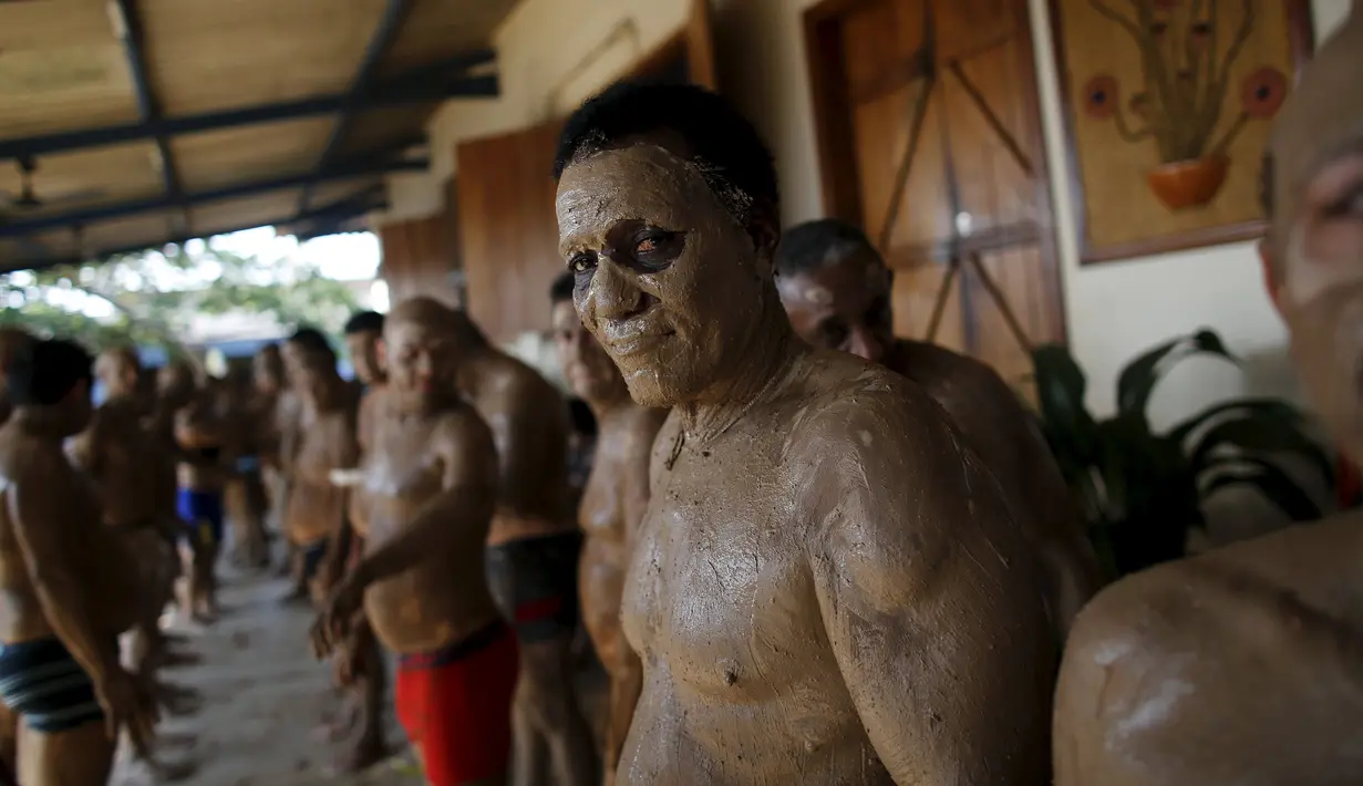 Seorang tahanan melumuri badannya dengan lumpur selama mengikuti terapi tanah liat di penjara Porto Velho, Brasil, (28/8/2015) . Kegiatan yang dilakukan seperti bermain bersama, pijat refleksi, pengetahuan spritual dll. (REUTERS/Nacho Doce) 