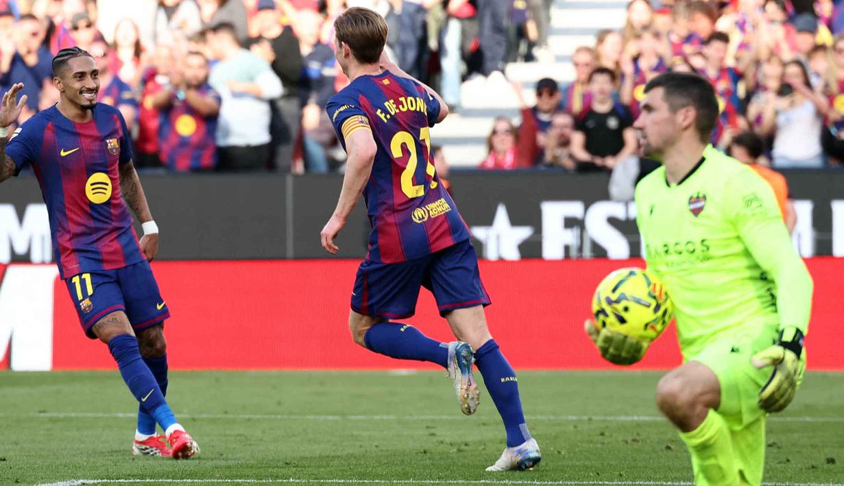 Tambahan tiga poin membuat Barcelona naik ke puncak klasemen dengan koleksi 61 angka. Mereka menggeser posisi Real Madrid dengan keunggulan satu poin. Tampak dalam foto, gelandang Barcelona asal Belanda, Frenkie De Jong (tengah) merayakan golnya bersama penyerang Barcelona asal Brasil, Raphinha, selama pertandingan pekan ke-25 La Liga 2025/2026 melawan Levante UD di Stadion Camp Nou, Minggu 22 Februari 2026. (Josep LAGO/AFP)