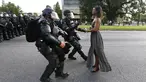 Polisi Anti Huru Hara AS bergegas menangkap seorang wanita yang melakukan unjuk rasa di dekat markas Kepolisian Rouge Baton di Baton Rouge, Louisiana, AS (9/7). Aksi tersebut sebagai kritik terkait kebrutalan polisi di AS. (REUTERS / Jonathan Bachman)