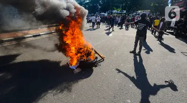 Massa membakar poster dan ban bekas saat aksi terkait putusan sengketa Pilpres di MK, di kawasan bundaran Patung Kuda, Jakarta, Senin (22/4/2024). (merdeka.com/Arie Basuki)