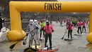 Peserta berkostum Star Wars Stormtrooper mencapai garis finis lomba dayung sambil berdiri pada Nautic SUP Paris di sungai Seine, Paris, Minggu (3/12). Nautic SUP Paris merupakan lomba dayung sambil berdiri terbesar di dunia. (AFP PHOTO/CHRISTOPHE SIMON)