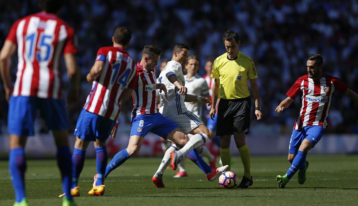 Bintang Real Madrid, Cristiano Ronaldo berusaha melewati adangan para pemain Atletico Madrid pada laga La Liga di Santiago Bernabeu stadium, Madrid, (8/4/2017). Real Madrid bermain Imbang 1-1 dengan Atletico. (AP/Daniel Ochoa de Olza)de Olza)