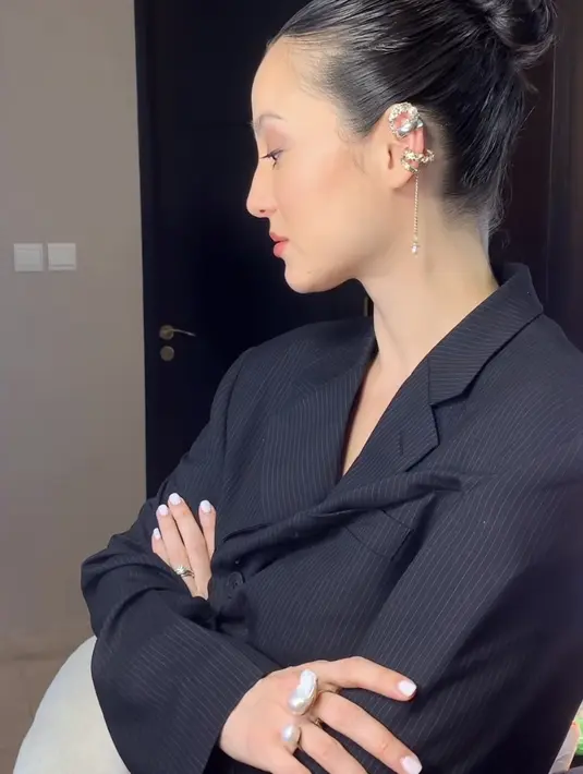 Hairstylist @iwanetaufik_hair pun menata rapi rambut Julie dengan ikat belakang model bun. Julie pun melengkapi penampilan dengan aksesori anting-anting dan cincinnya.[ @iwanetaufik_hair ]