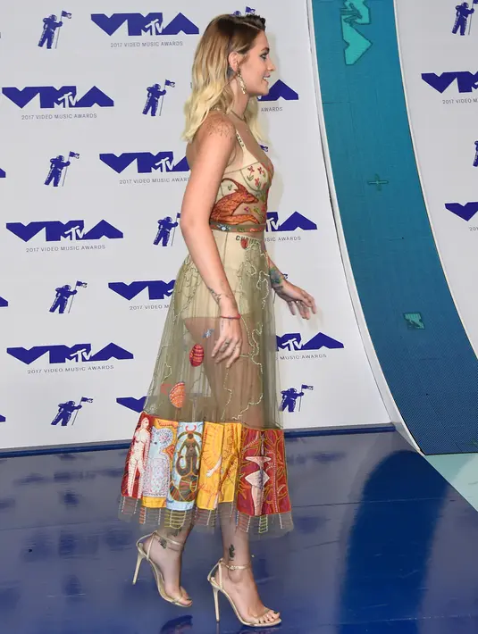 Paris Jackson setibanya pada ajang MTV Video Music Awards (VMA) 2017 di Inglewood, California, Minggu (27/8). Gaun transparan berwarna kuning emas dengan hiasan sulaman memperlihatkan bra dan celana pendeknya.  (Jordan Strauss/Invision/AP)