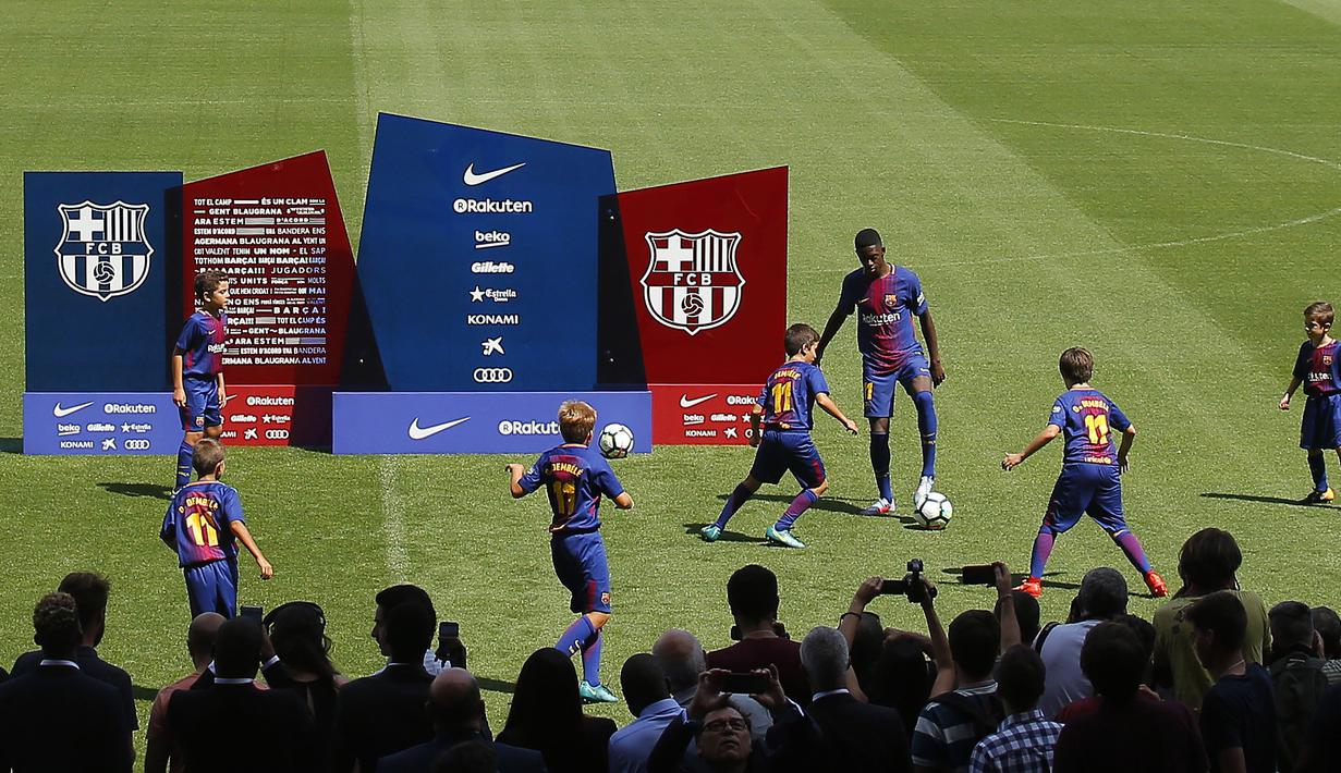 Ousmane Dembele beradu skil dengan anak-anak saat perkenalan di Camp Nou stadium, Barcelona, (27/8/2017). Barcelona menebus Ousmane Dembele sebesar Rp. 2,3 triliun dari Dortmund. (AP/Manu Fernandez)