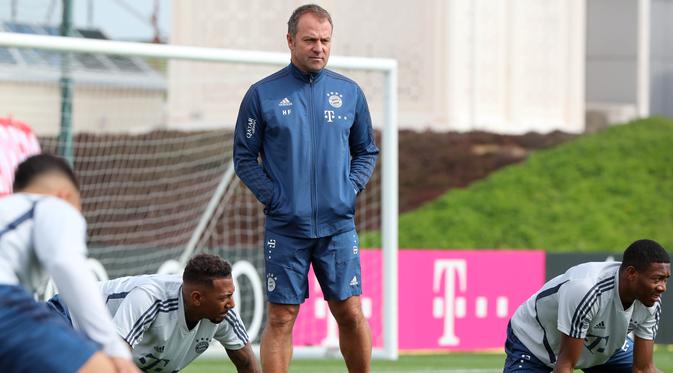 Pelatih Bayern Muenchen, Hansi Flick, mengamati anak asuhnya saat latihan Senin (6/4/2020). Pemuncak klasemen sementara liga Jerman ini berlatih bersama untuk pertamakalinya sejak Bundesliga dihentikan pada 13 Maret karena virus corona. (AFP/Christof Stache)