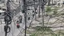 Kendaraan melintas dekat instalasi kabel yang semrawut di Jalan Raya Bekasi, Cakung, Jakarta, Rabu (30/9/2020). Minimnya perawatan pascapembebasan lahan permukiman untuk proyek Tol Dalam Kota membuat jaringan kabel listrik di sepanjang jalan tersebut semrawut. (merdeka.com/Iqbal S. Nugroho)
