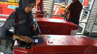 Calon penumpang TransJakarta melakukan tapping (menempelkan) e-ticketing di koridor I Harmoni, Jakarta, (23/10/14). (Liputan6.com/Faizal Fanani)