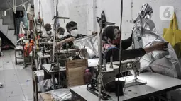 Pekerja menyelesaikan pembuatan baju hazmat di salah satu industri konveksi Pusat Industri Kecil (PIK), Jakarta, Rabu (30/12/2020). Permintaan baju hazmat hingga kini masih tinggi seiring terus meningkatnya kasus COVID-19 di Indonesia. (merdeka.com/Iqbal S. Nugroho)