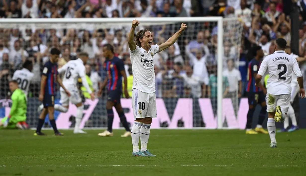 Pemain Real Madrid, Luka Modric merayakan gol ke gawang Barcelona pada laga Liga Spanyol 2022/2023 di Santiago Bernabeu Stadium, Madrid (16/10/2022). Real Madrid menjadi klub Spanyol yang paling sering mengalahkan Barcelona di semua ajang. Dari total 252 laga, Barcelona tercatat kalah 102 kali dan menang dalam 99 laga. (AFP/Pierre-Philippe Marcou)